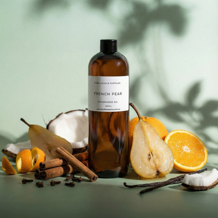 Bottle of 'French Pear' fragrance oil with fruits and spices on a green background