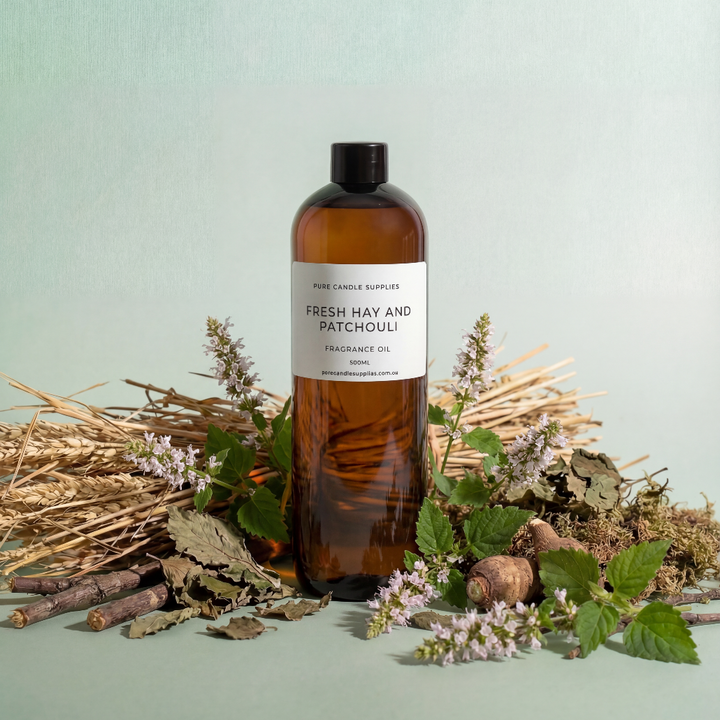 Bottle of 'Fresh Hay and Patchouli' fragrance oil with natural elements on a light green background