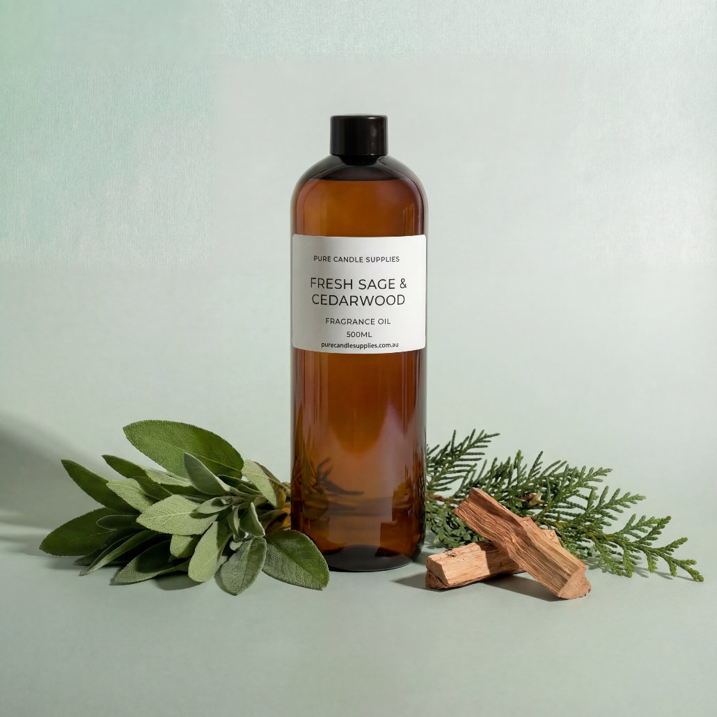 Bottle of Fresh Sage & Cedarwood fragrance oil with green leaves and wood on a light gray background