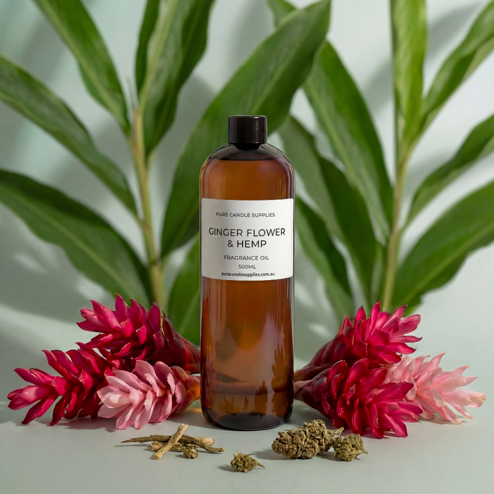 Bottle of Ginger Flower & Hemp fragrance oil with flowers and herbs on a light background