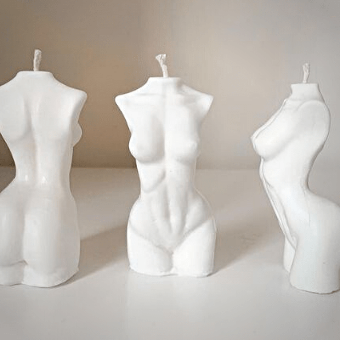 three female body candles in white colour on varying angles on beige background
