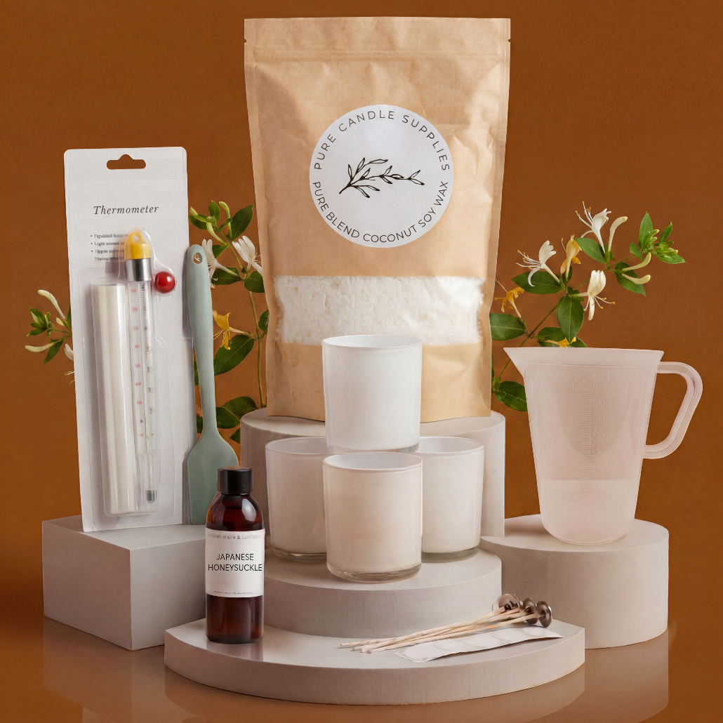 Collection of candles, packaging, and accessories on a reflective surface with a brown background