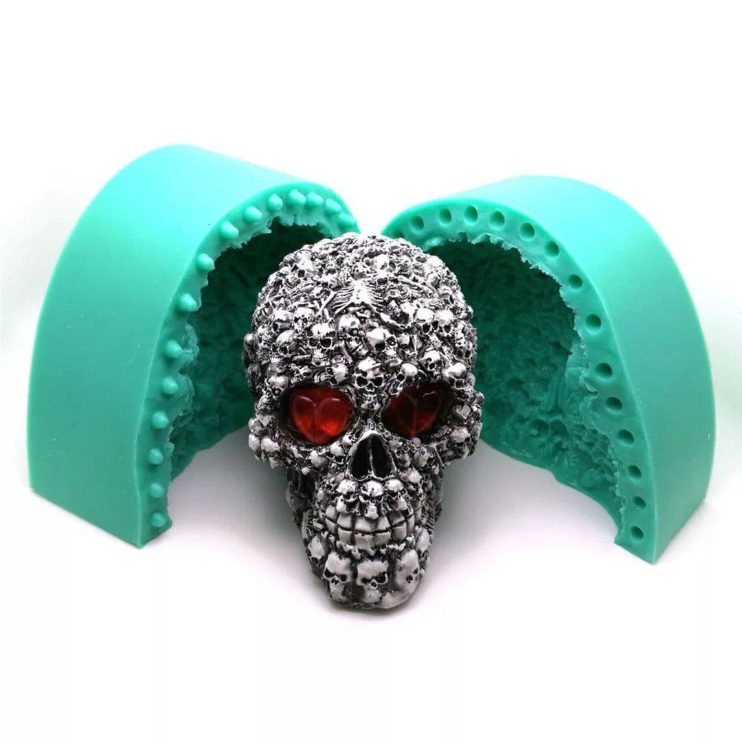 black and white skull candle sitting in front of green silicone mould on white background
