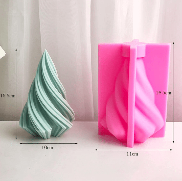 large green spiral christmas tree candle next to pink silicone mould against white background