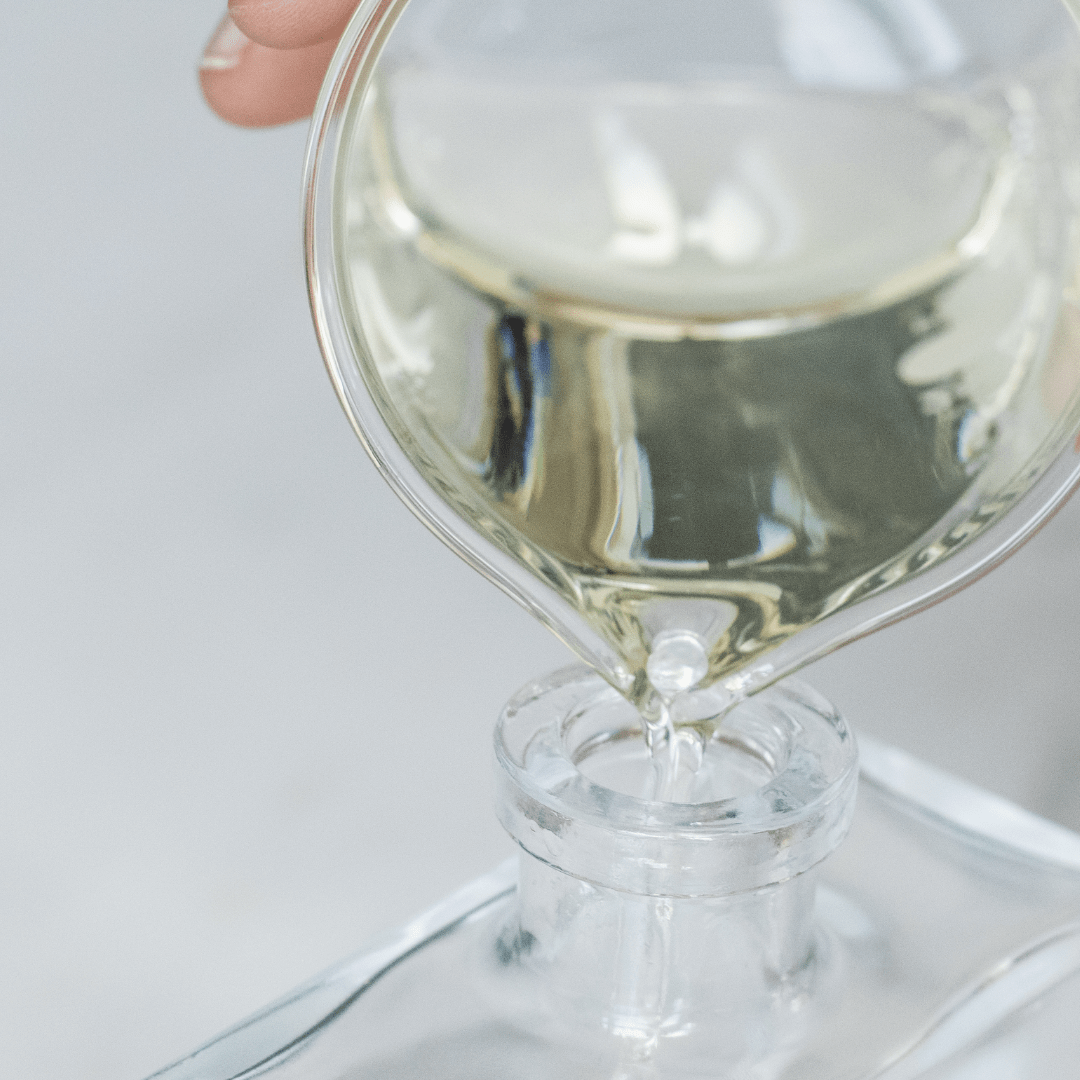 liquid being poured from beaker into diffuser jar