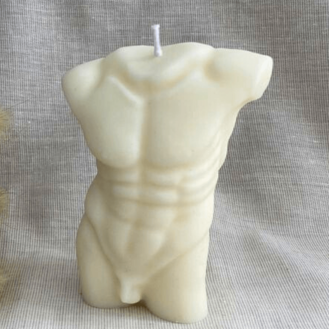 male torso shaped candle in white wax on grey background