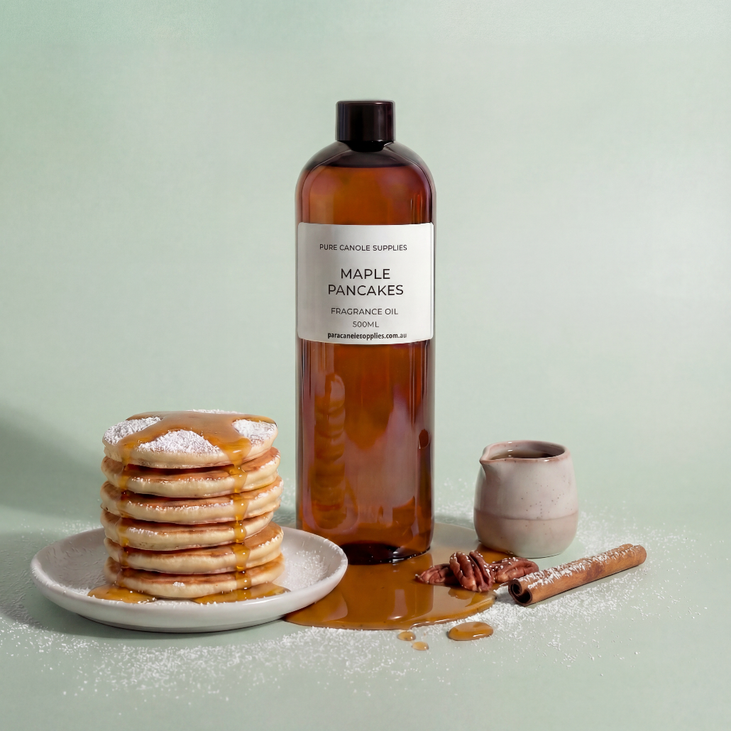Bottle of 'Maple Pancakes' fragrance oil with a stack of pancakes and cinnamon sticks on a light green background