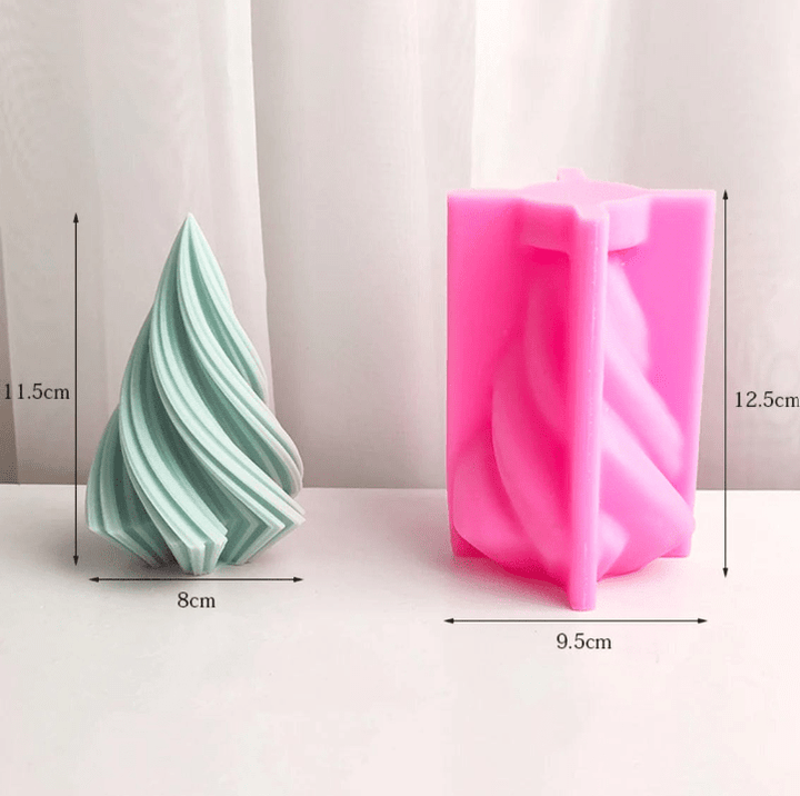 medium green spiral christmas tree candle next to pink silicone mould against white background