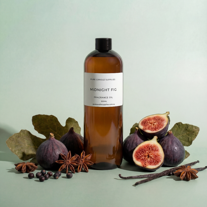 Bottle of 'Midnight Fig' fragrance oil with figs and vanilla beans on a light green background
