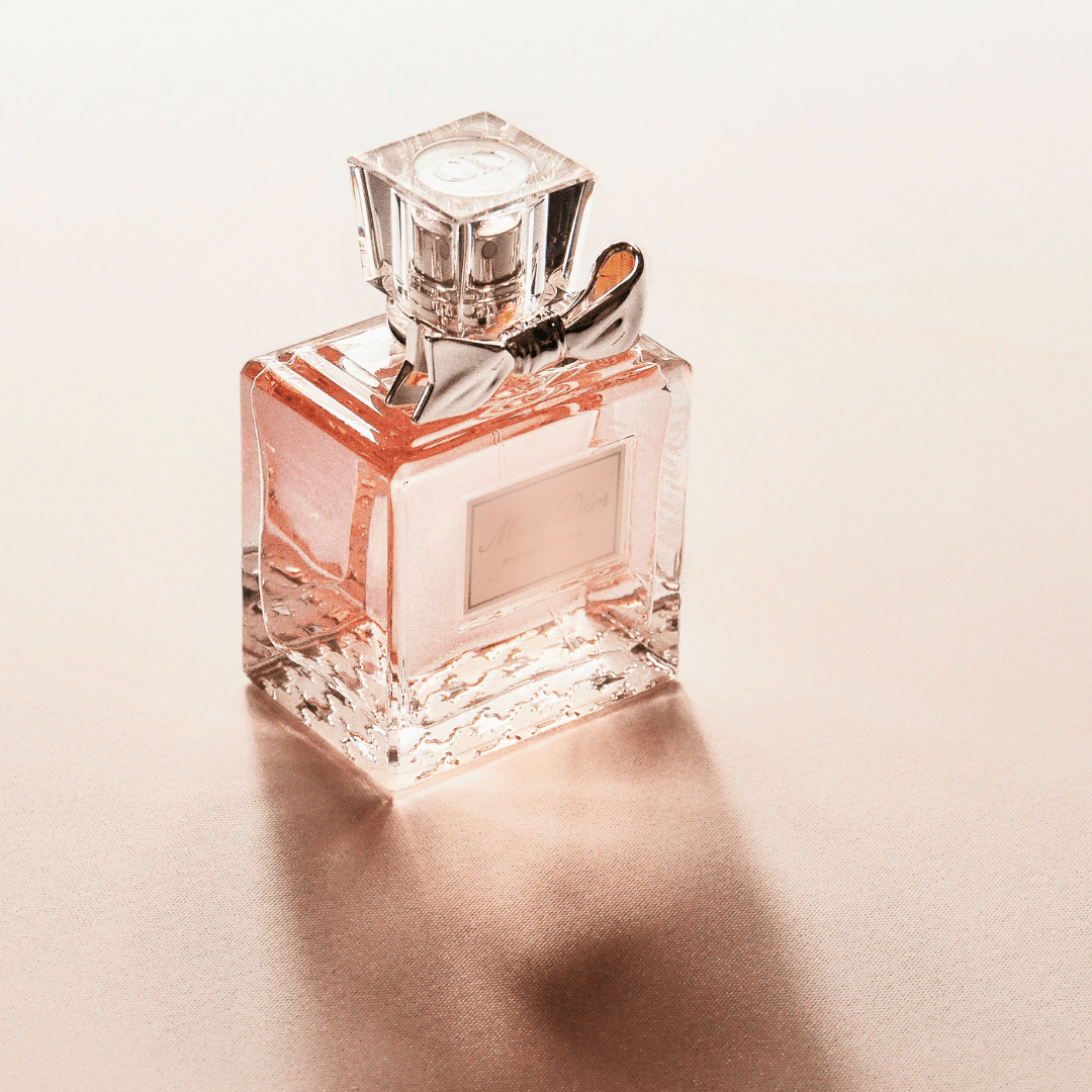 square bottle of perfume with bow underneath cap