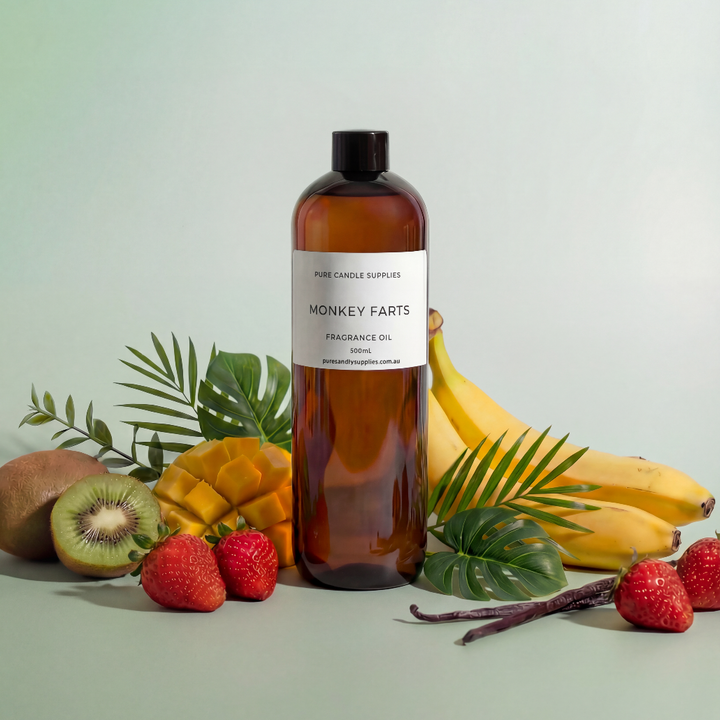 Bottle of 'Monkey Farts' fragrance oil with fruits and leaves on a light background