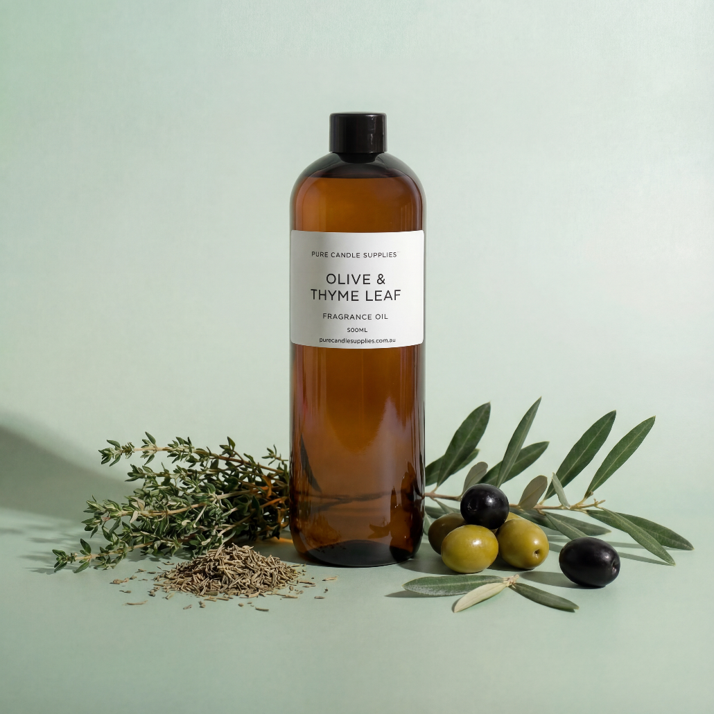 Bottle of olive and thyme leaf fragrance oil with olives and thyme on a light green background