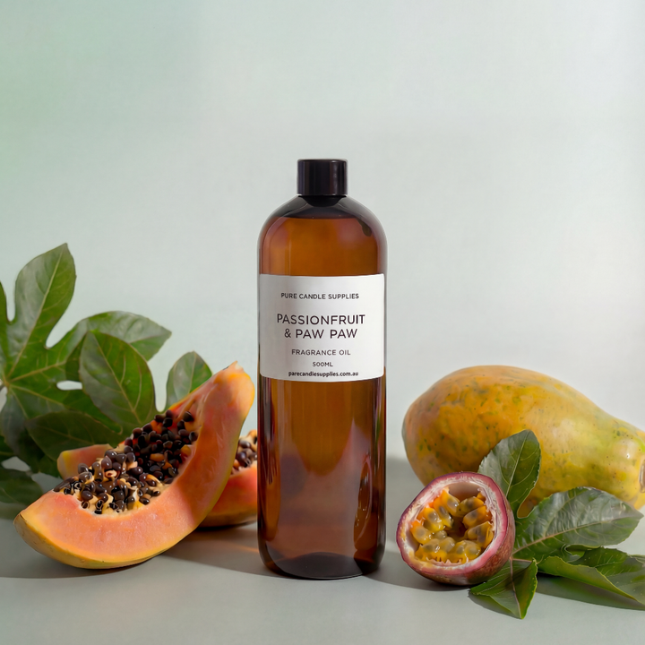 Bottle of passionfruit and paw paw fragrance oil with passionfruit and paw paw fruits on a light background