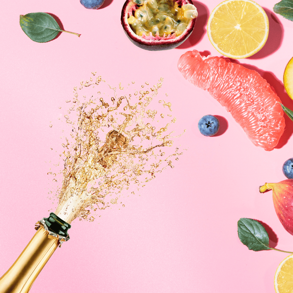 assorted fruits with popped bottle of champagne