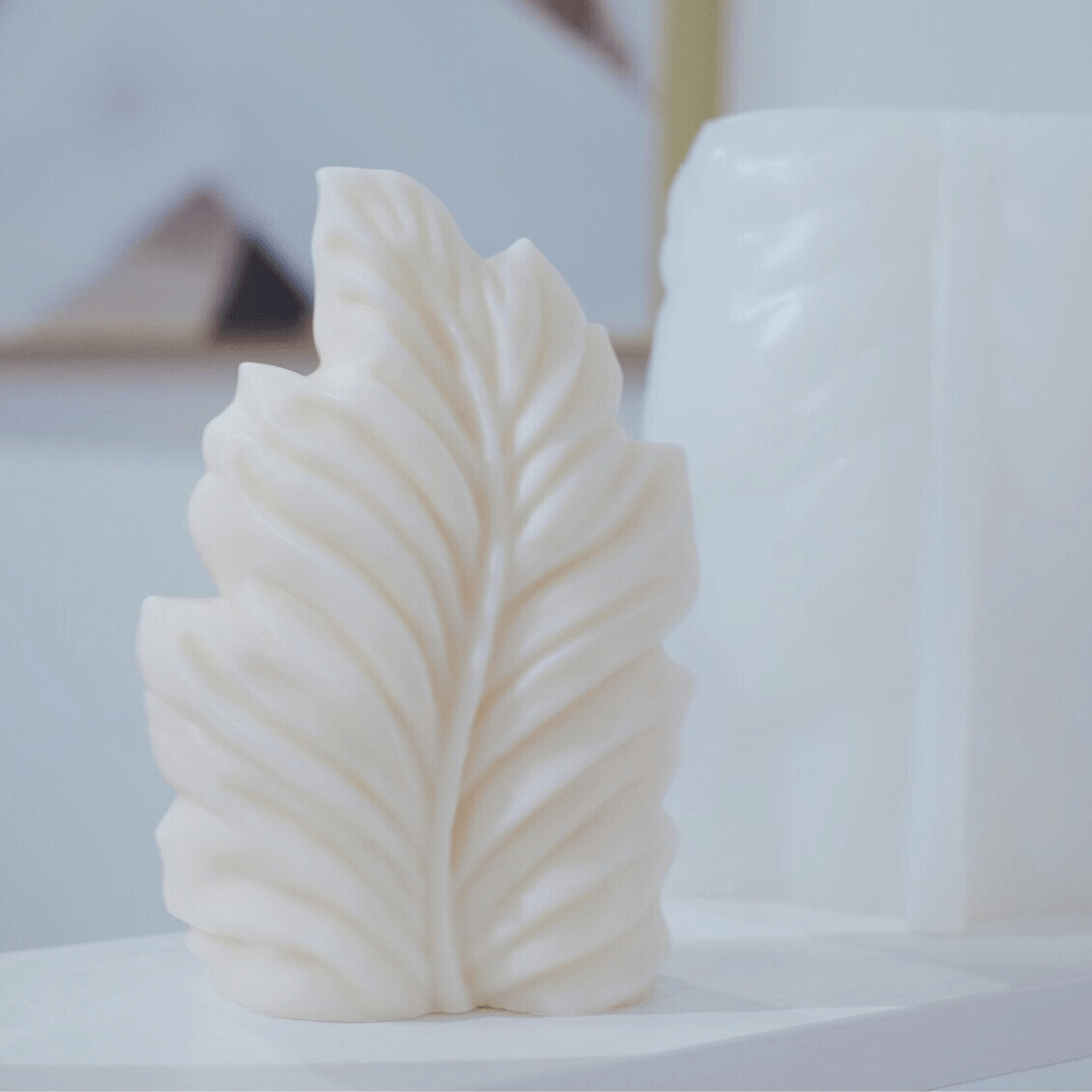 palm leaf shaped candle mould in white wax with silicone mould in background 
