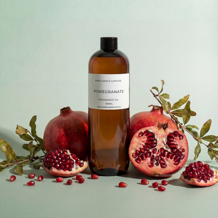 Bottle of pomegranate fragrance oil with pomegranates and leaves on a light background