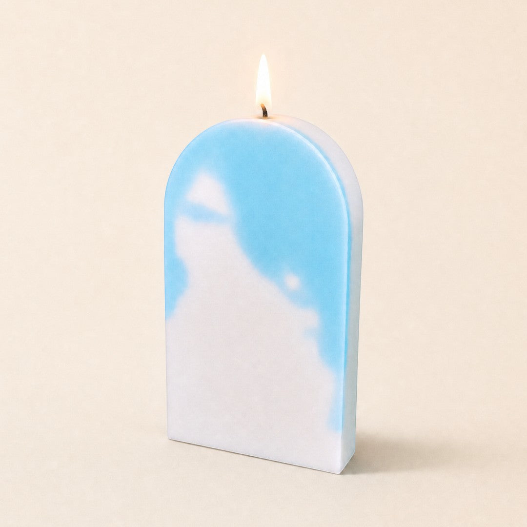Pure Candle Supplies Melbourne arch shaped candle with a blue and white marbled wax finish and a lit wick