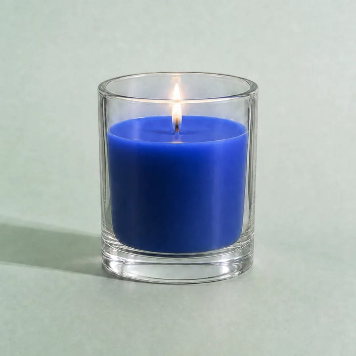 Pure Candle Supplies Melbourne dark blue candle in a clear glass container with a lit wick