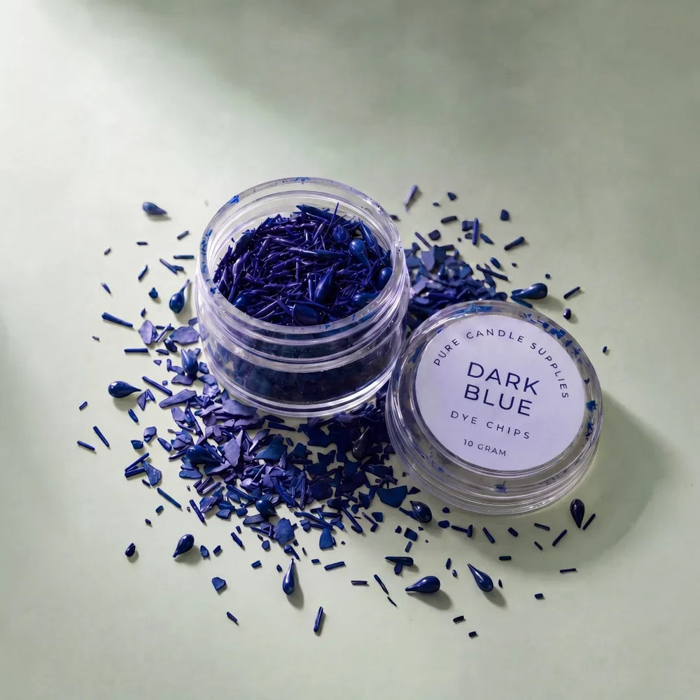 Pure Candle Supplies Melbourne dark blue candle dye chips in a small clear jar on a light green surface.