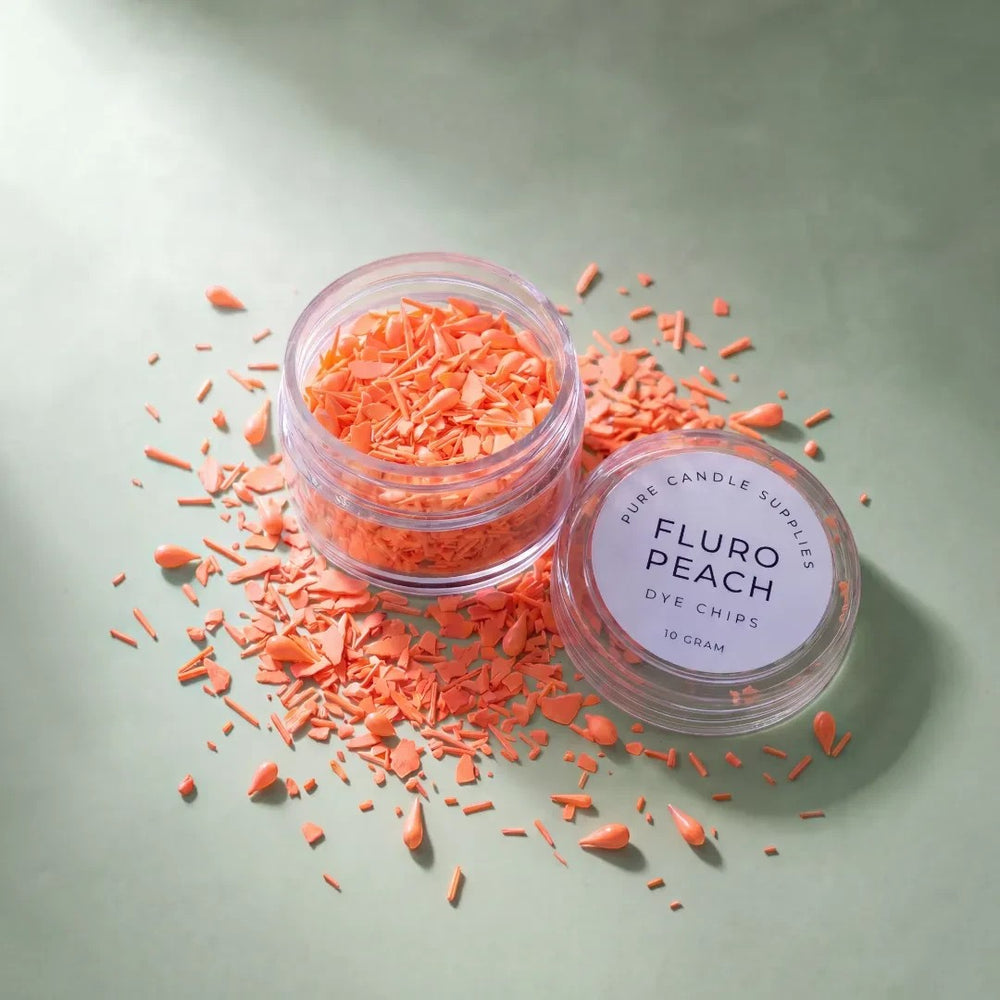 Pure Candle Supplies Melbourne fluro peach candle dye chips in a small clear jar on a sage green background.