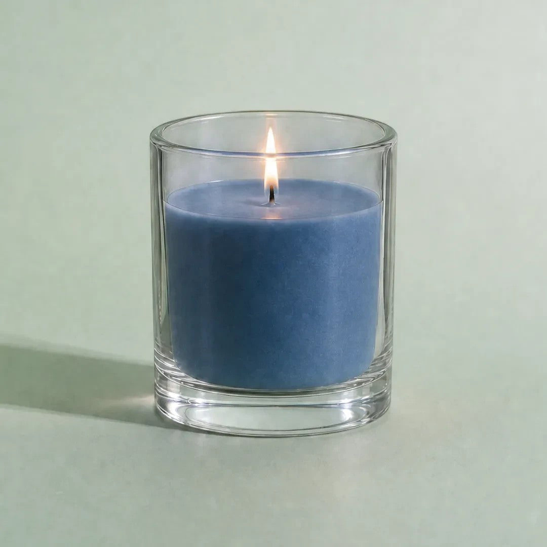 Pure Candle Supplies Melbourne light blue candle made with dye chips in a clear glass container with a lit wick.
