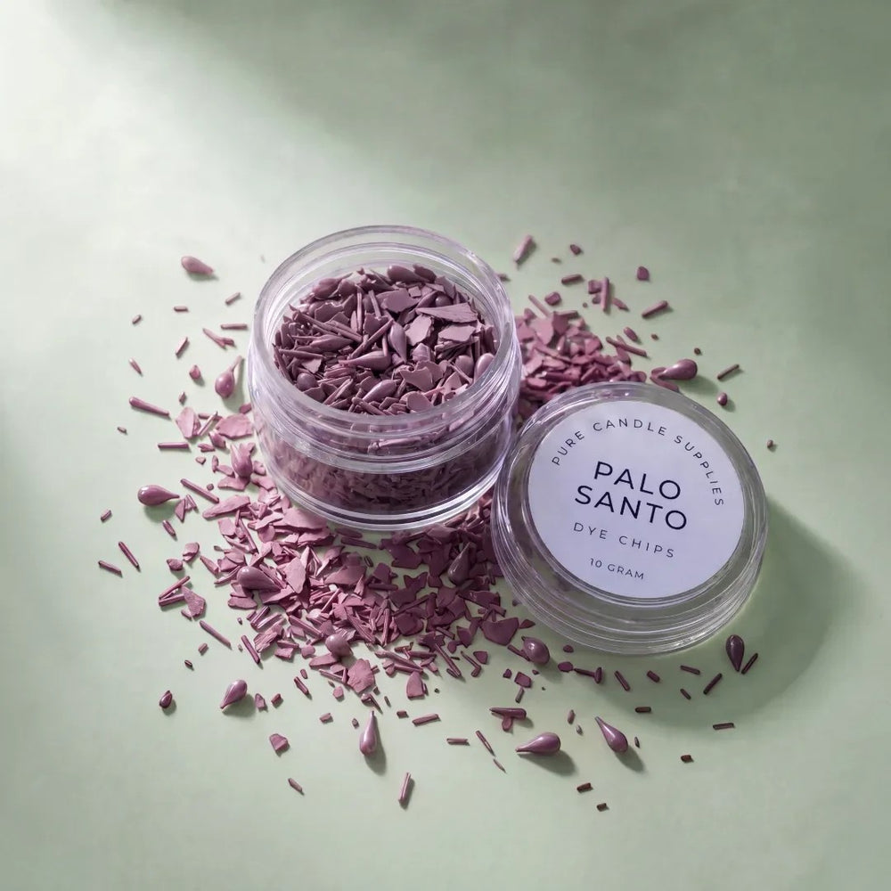 Pure Candle Supplies Melbourne Palo Santo dye chips in a small jar with scattered purple wax pieces on a green surface
