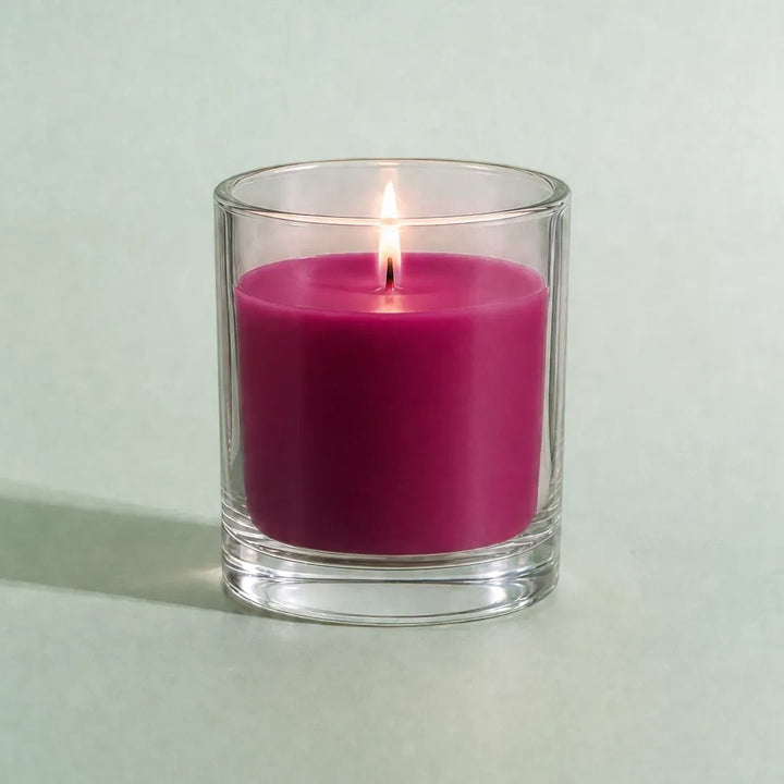 Pure Candle Supplies Melbourne Paradise dye chip coloured wax in a clear glass container with a lit candle wick