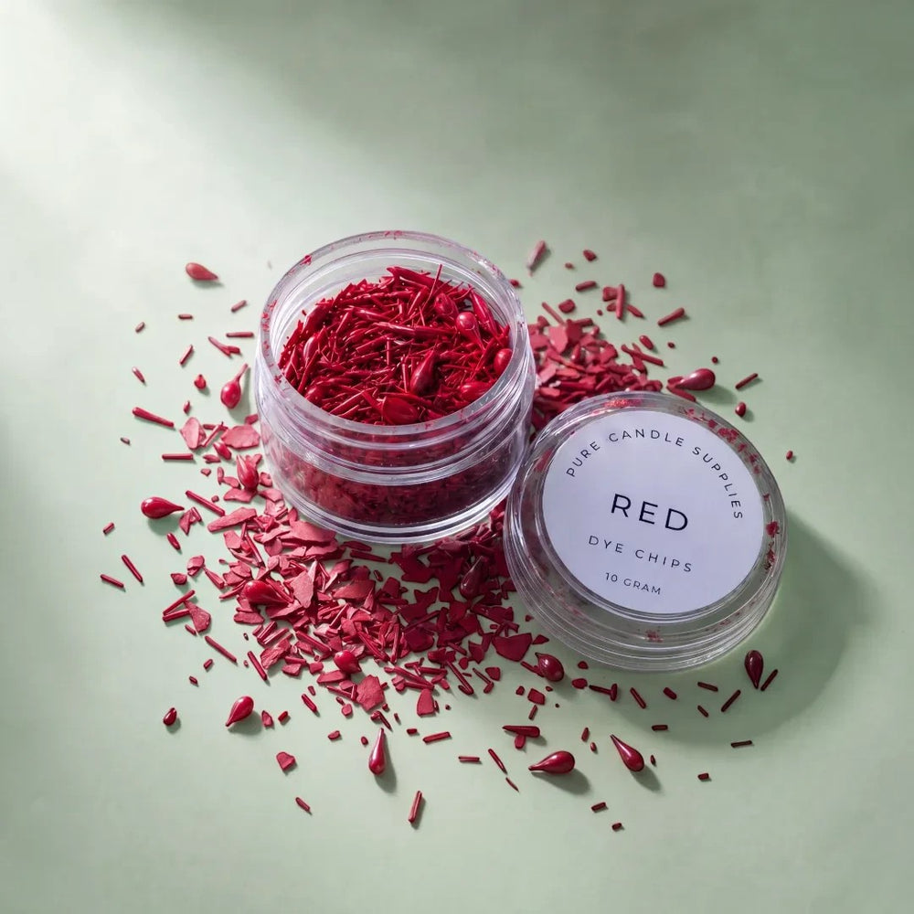 Pure Candle Supplies Melbourne red dye chips for candle making in a small clear jar on a soft green background.