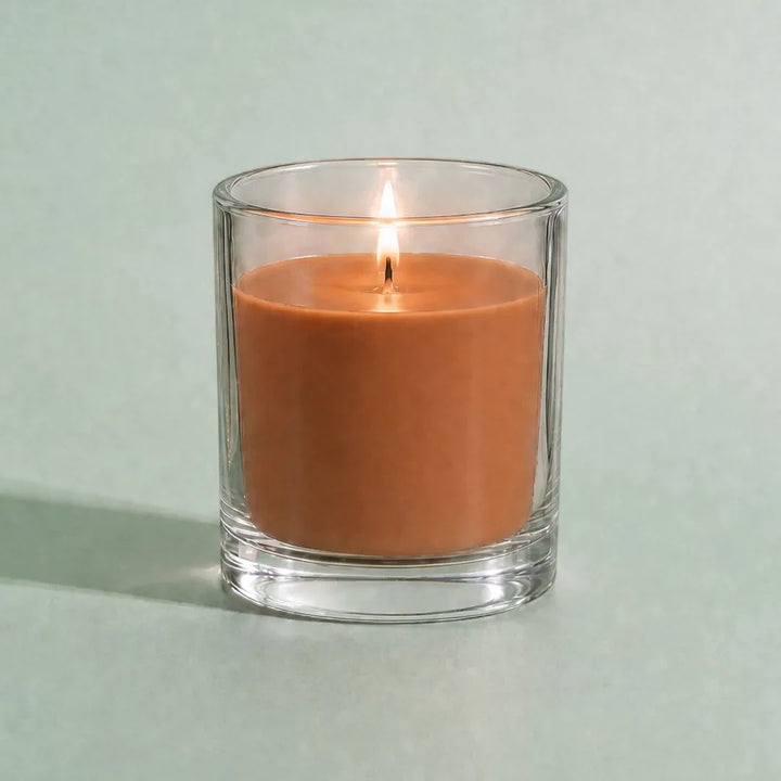 Pure Candle Supplies Melbourne terracotta dye chip coloured candle in a clear glass container with a lit wick