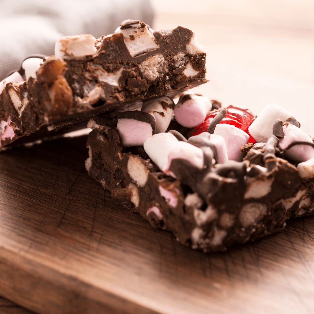 Biscuit and chocolate base with pink and white marshmallow pieces and cherries throughout