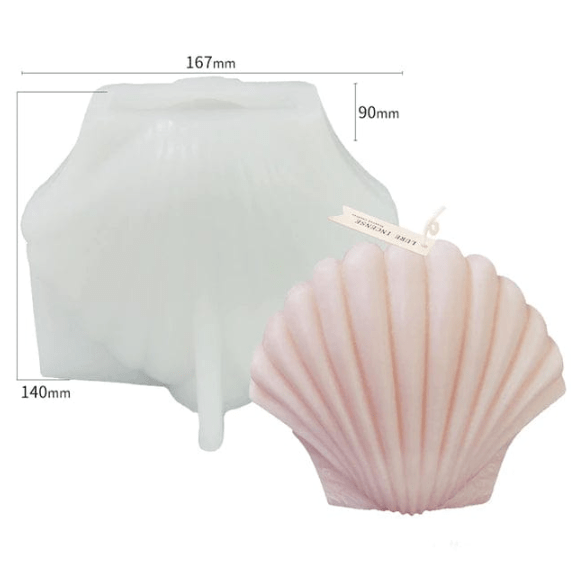 scallop shaped candle in pink wax in front of silicone mould with size reference