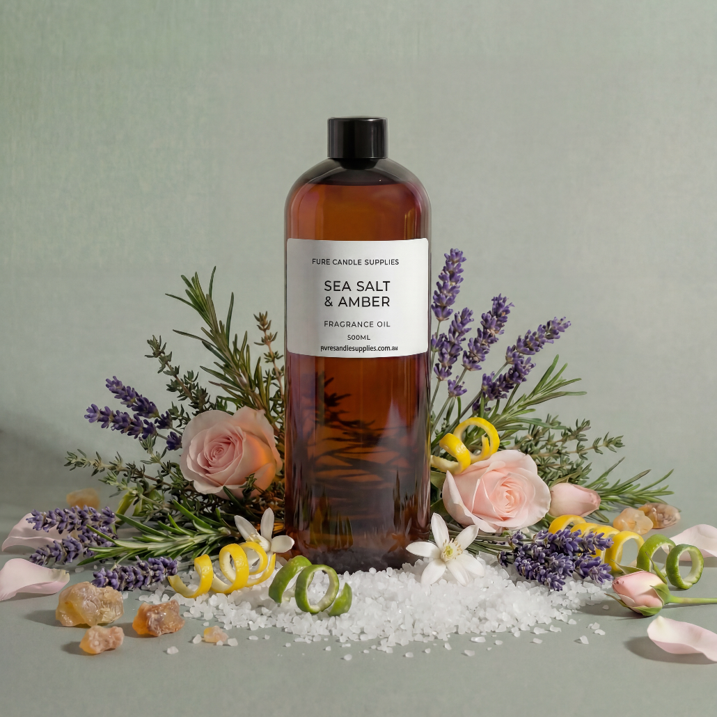 Bottle of 'Sea Salt & Amber' fragrance oil surrounded by flowers and sea salt crystals on a light green background