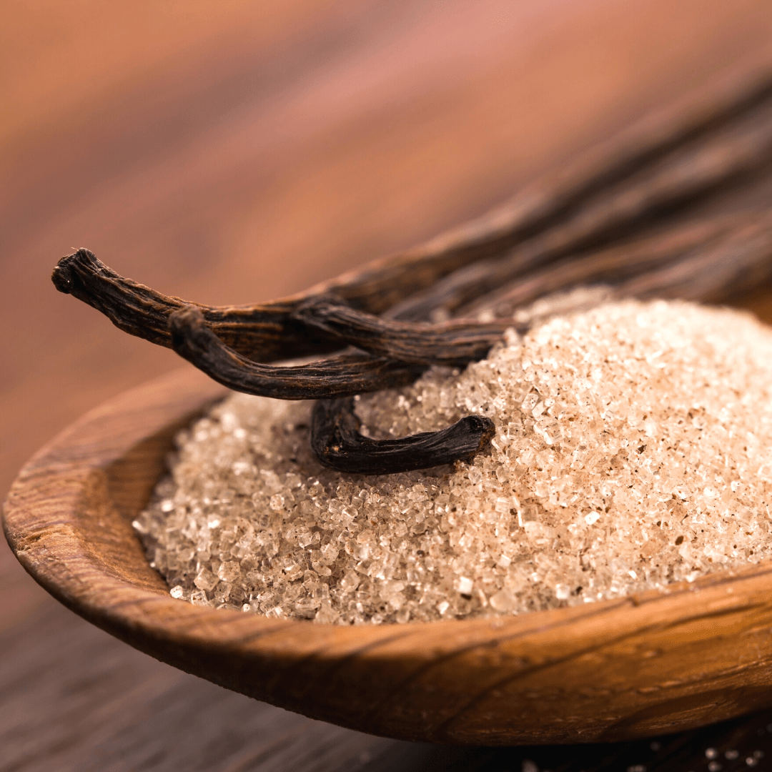 vanilla bean quills resting on top of salt in wooden bowl