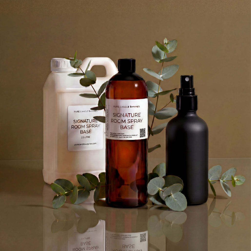 Three bottles of room spray on a reflective surface with eucalyptus leaves against a brown background
