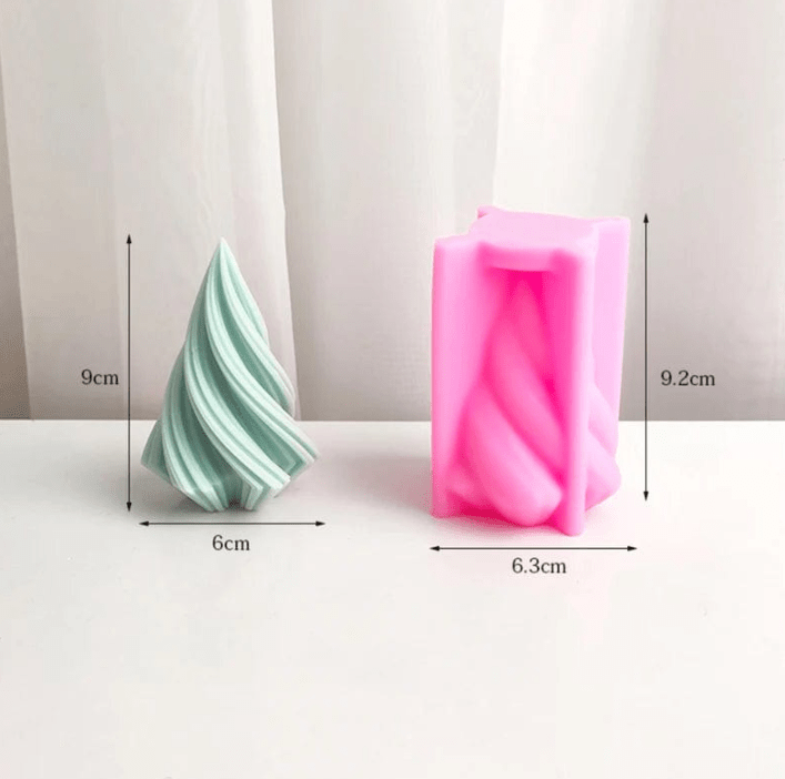 small green spiral christmas tree candle next to pink silicone mould on white background