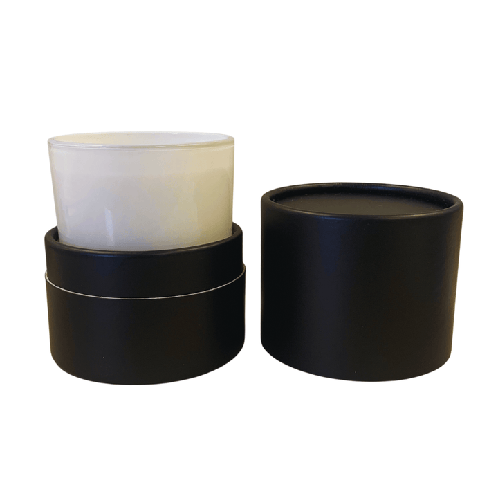 tube candle packaging in matte black finish with white glass inserted 