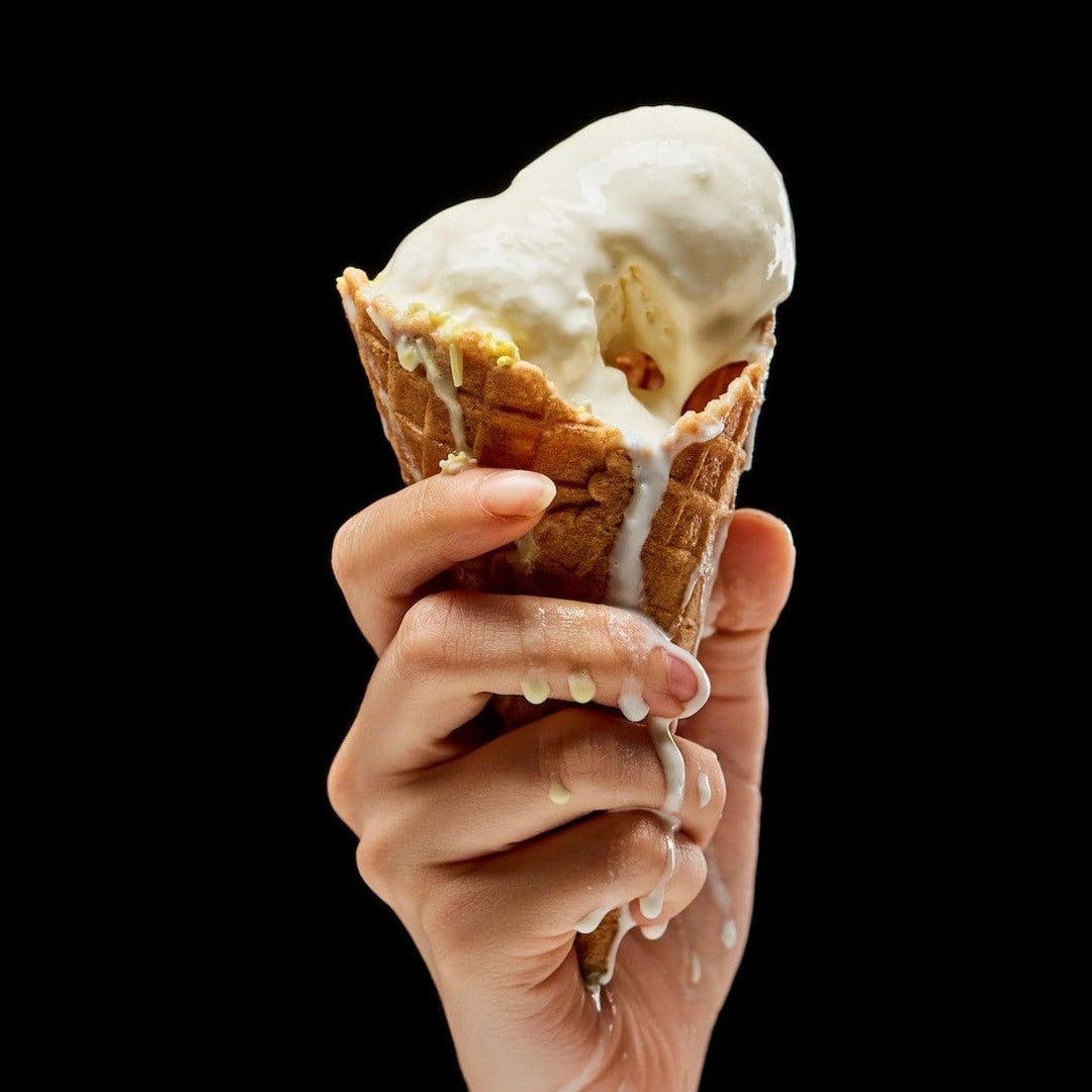 vanilla ice cream in waffle cone, melting onto hand 