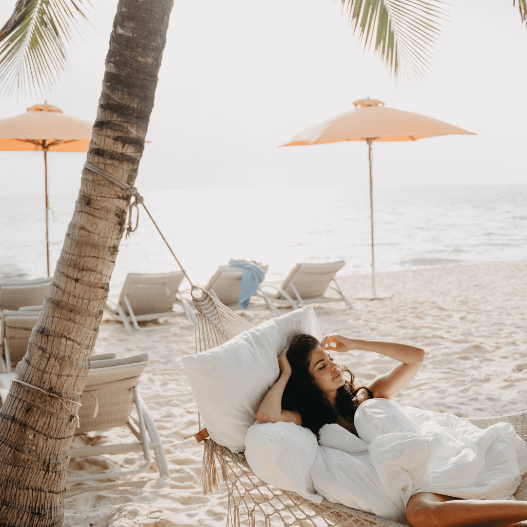 lady in hammock on the beach with fresh linen  comfroter and pillow