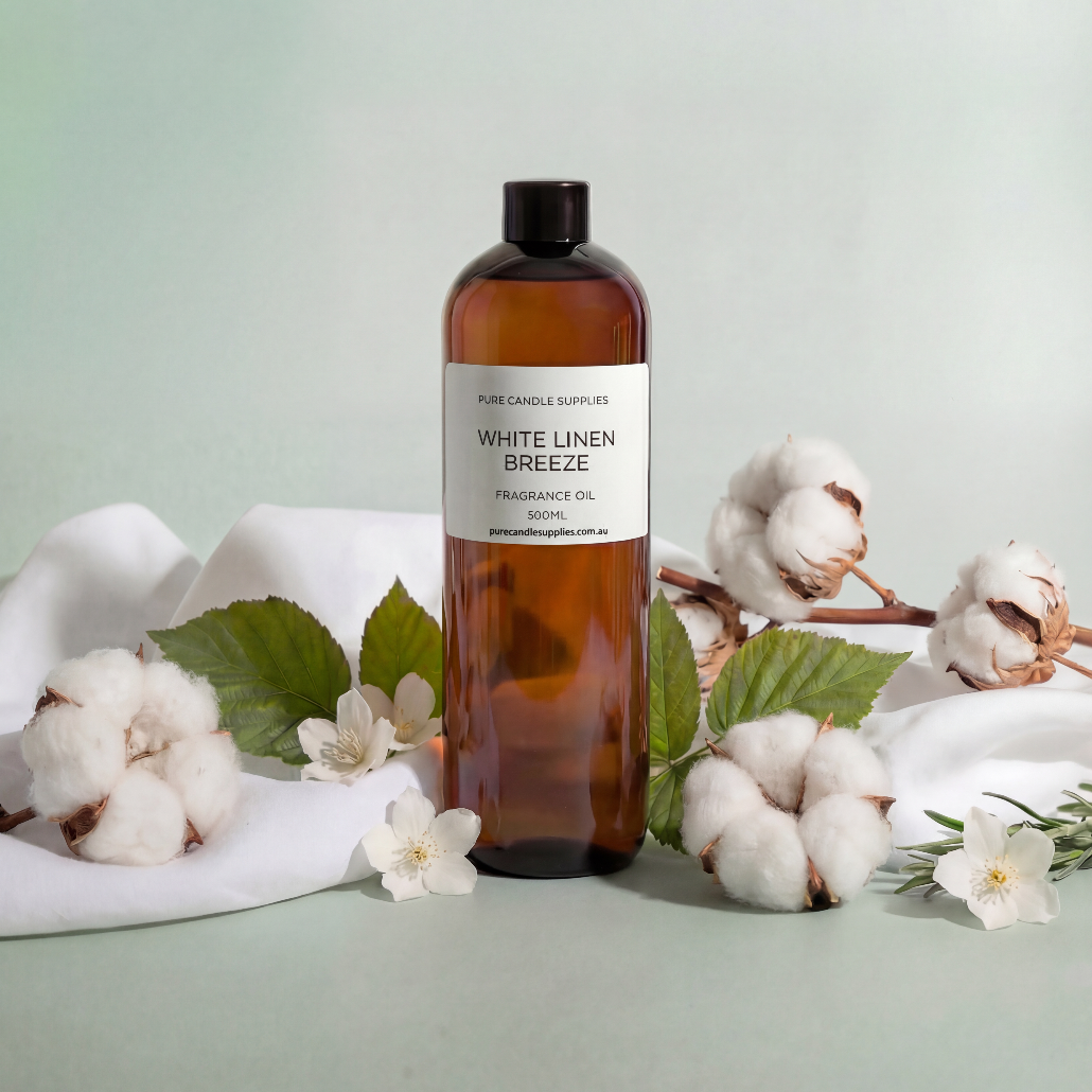 Bottle of 'White Linen Breeze' fragrance oil with cotton flowers and leaves on a light green background