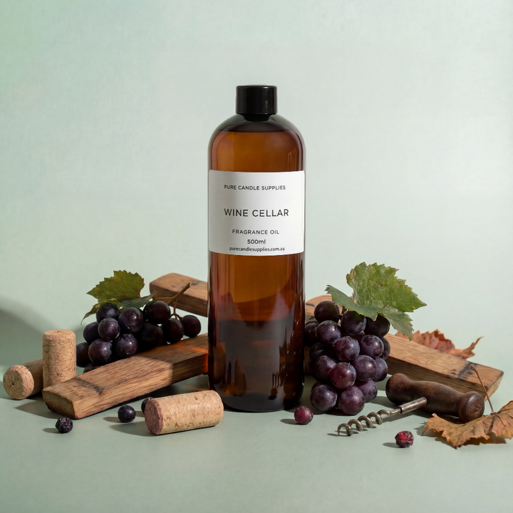 Bottle of 'Wine Cellar' fragrance oil with grapes and corks on a light green background